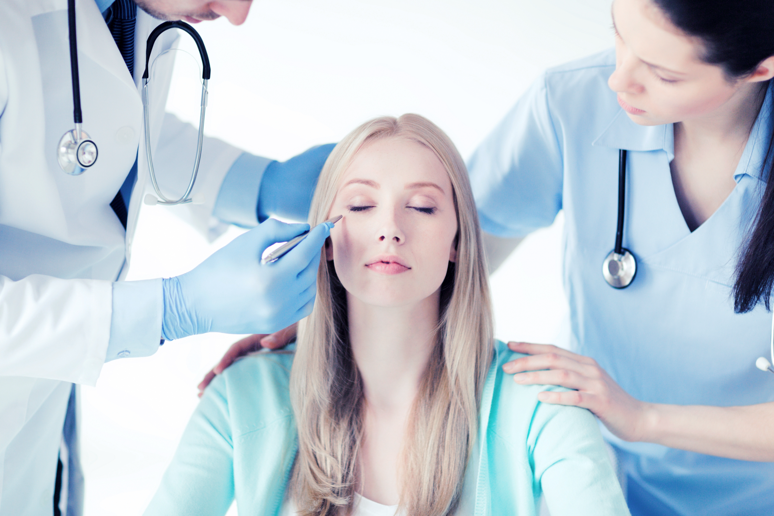 Image of woman being checked by doctor and nurse